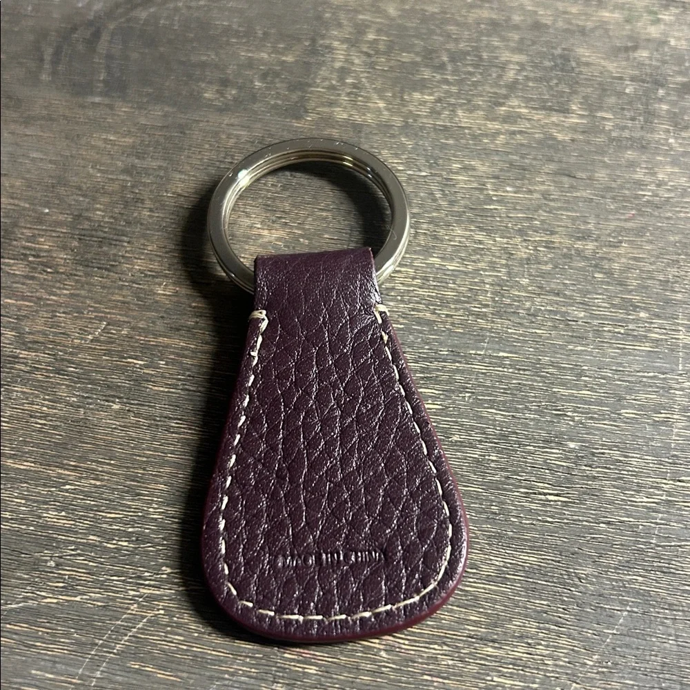 Dooney & Bourke leather key fob, featuring‎ an embossed logo dark plum